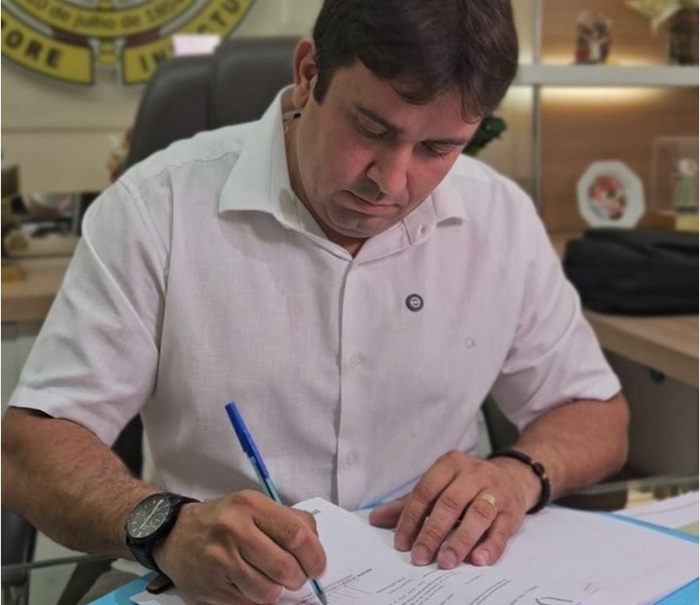Helder assinando